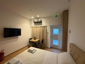 a room with a bed and a table and a television at Prime 27 Luxury Studio in Lavrio