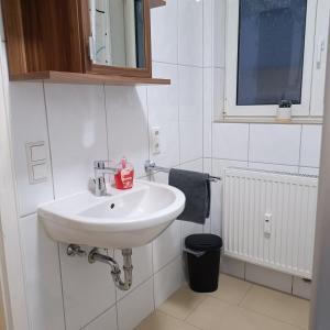 a bathroom with a white sink and a window at City-Quartier in Bad Mergentheim