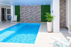 a swimming pool in the middle of a house at Delfin Hotel Collection Rodadero in Rodadero
