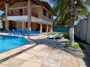 a villa with a swimming pool and a house at Linda casa próximo do Beach Park in Aquiraz