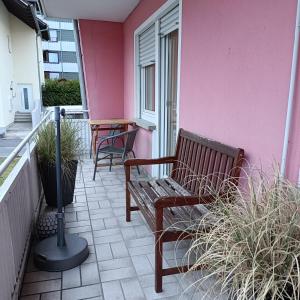 a bench sitting on a balcony with a pink wall at City-Quartier in Bad Mergentheim