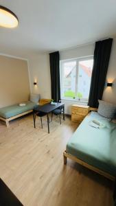 a room with two beds and a table and a window at Aparthotel Grünewald in Hannover