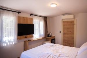 a bedroom with a bed and a flat screen tv at Sunmed Lodge in Oludeniz