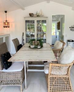 a dining room with a wooden table and wicker chairs at House On Femø With Large Patio in Maribo +21 photos