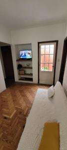 a living room with a television and a white rug at Departamento luminoso con balcón in La Plata