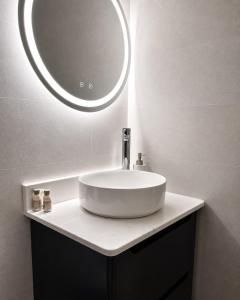a bathroom sink with a round mirror above it at The Hillcrest, Luxury Accommodation in Castleblayney Town in Castleblayney +37 photos