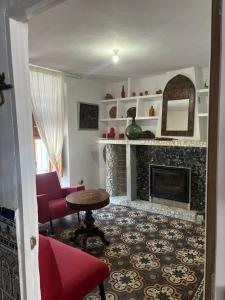 a living room with a fireplace and a table at El Patio de Doña Tere in Villarta de San Juan