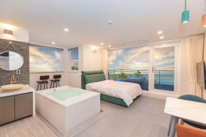 a bedroom with a bed and a view of the ocean at Donghae aeodalari pension in Donghae