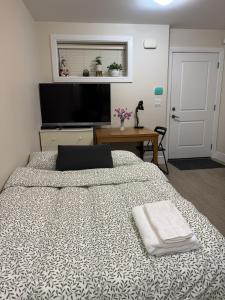 a bedroom with a large bed and a television at Garden suite in Vancouver