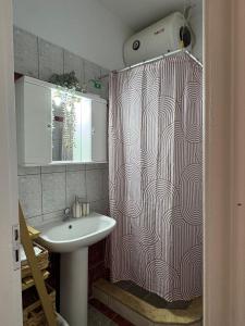 a bathroom with a sink and a shower curtain at Rocky Stays - Argostoli Central Studio in Argostoli +13 photos