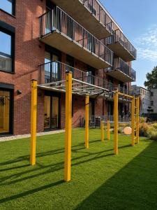 a group of yellow poles in the grass in front of a building at Slovianka Residence - strefa spa oraz darmowy parking! in Łódź