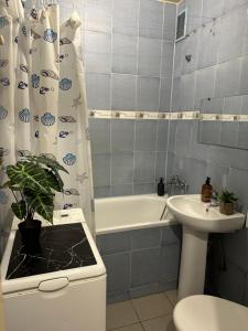 a bathroom with a sink and a tub and a toilet at Horodotska Street in Lviv