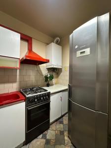 a kitchen with a stove and a refrigerator at Horodotska Street in Lviv