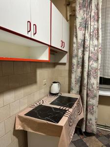 a kitchen with a stove top oven next to a curtain at Horodotska Street in Lviv
