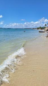 a beach with the ocean and the water at Casa no centro de Ponta de Pedras - Casa da Baleia VILA ORION in Goiana +11 photos