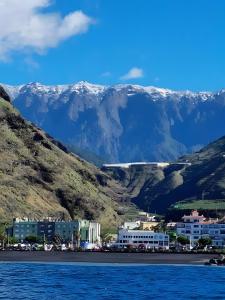 a town on the shore of the water with mountains in the background at Casa Goro in Tazacorte