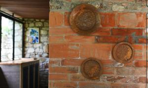 a brick wall with copper plates on it at Filoxenia - The Place of Experience in Himare +101 photos