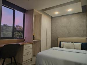 a bedroom with a bed and a desk and a window at Coastal Calm The Cove 2 in Flic-en-Flac +8 photos