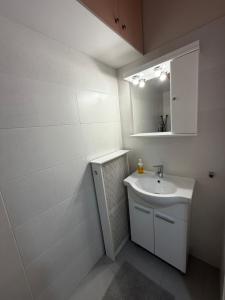 a white bathroom with a sink and a mirror at City View Apartment in Mytilene +8 photos