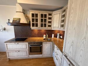 a kitchen with white cabinets and a sink at Masti Apartment in Tallinn +11 photos