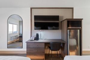a bedroom with a desk and a mirror and a bed at Zion Promenade Hotel in St. George
