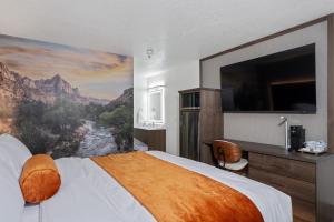 a hotel room with a large bed with a painting on the wall at Zion Promenade Hotel in St. George