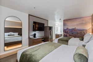 a hotel room with two beds and a painting on the wall at Zion Promenade Hotel in St. George