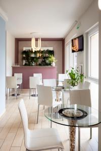 a dining room with a glass table and white chairs at Hotel Rossovino Como in Como
