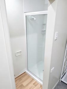 a white closet with a glass door in a room at Eco Lodge Pakowhai in Hastings