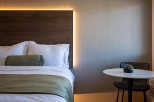 a hotel room with a bed and a table at Zion Promenade Hotel in St. George