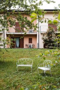 two benches sitting in the grass in front of a building at Hotel Rossovino Como in Como