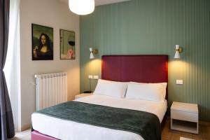 a bedroom with a large bed with a red headboard at Hotel Rossovino Como in Como +69 photos