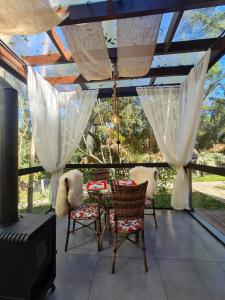 a patio with a table and chairs and a heater at Chalés Serras House Casa Verde e Casa Laranja in São Francisco de Paula