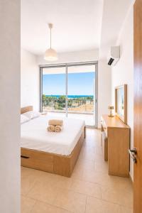 a bedroom with a bed and a large window at Best Seaview in Larnaca - 2 BDR Apt - 2 Min Walk to Beach in Larnaca