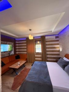 a bedroom with a bed and a couch at Hotel Exclusive in Tirana