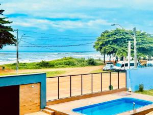 a hot tub on a balcony with a view of the ocean at Pousada Sol & Mar Jacaraìpe ES in Serra