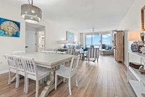a dining room and living room with a table and chairs at Modern Gulf Front Condo, Pool, 2 Hot Tubs, Platinum Beach Service, Endless Views in Navarre