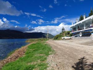 a road next to a lake next to a building at Mi Hacienda Pacucha in Andahuaylas