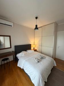 a bedroom with a large white bed and a lamp at City View Apartment in Mytilene