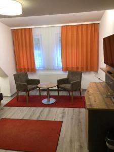 a living room with two chairs and a table at Gasthaus Hotel Löffelschmiede in Hinterzarten