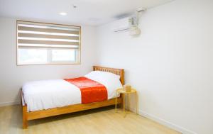 a bedroom with a bed and a window in it at Yang Yang Timi House Pension in Yangyang