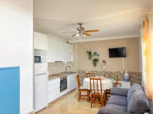 a kitchen and a living room with a couch and a table at Casa da Pedra in Moledo