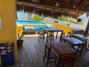 a restaurant with tables and a swimming pool at Casa Velero Puerto Morelos in Puerto Morelos