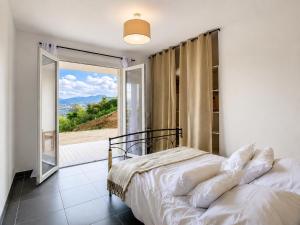 a bedroom with a bed and a large window at Villa Muvra in Ajaccio