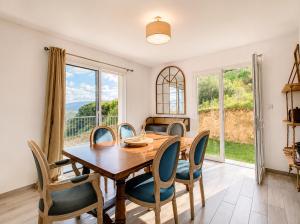 a dining room with a wooden table and chairs at Villa Muvra in Ajaccio