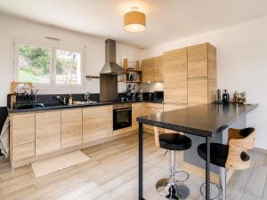 a kitchen with a black table and wooden cabinets at Villa Muvra in Ajaccio