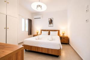 a bedroom with a large bed with white sheets at Dorothy's Apartments Near Athens Airport By SEM in Artemida
