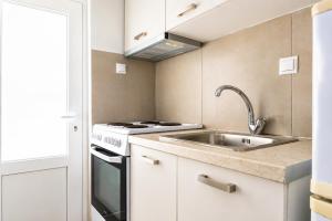 a kitchen with a sink and a stove at Dorothy's Apartments Near Athens Airport By SEM in Artemida