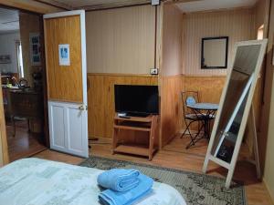 a bedroom with a bed and a tv and a room with a ladder at Hostal Destino Bellavista in Valparaíso