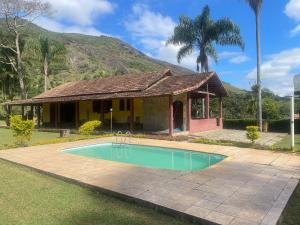 a house with a swimming pool in front of a house at Cozy Farmhouse with Pool in Bom Jardim in Bom Jardim